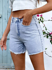 Close-up of front pocket on light-wash frayed denim shorts