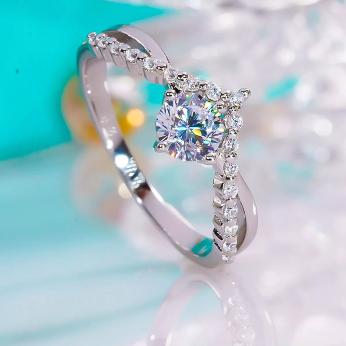 Close-up of the blue rectangular gemstone and silver ring setting held between fingers.