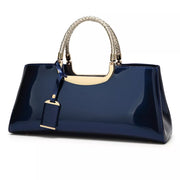 Navy patent-look handbag with braided top handles and hanging tag