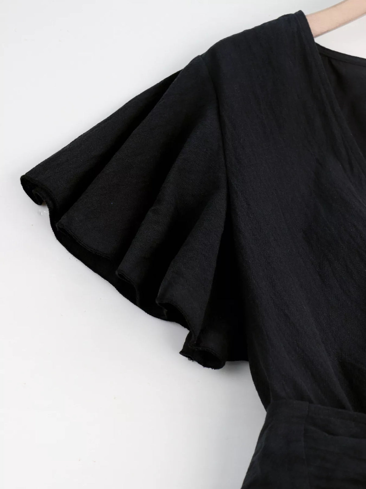 Close-up of black flutter sleeve and fabric