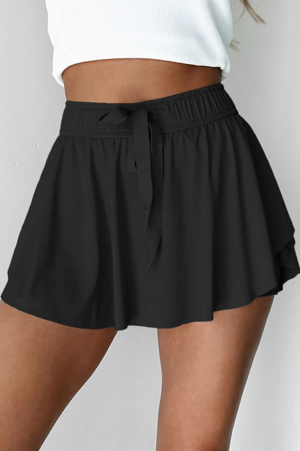 Front view of blue skort showing the gathered waist and long drawstring