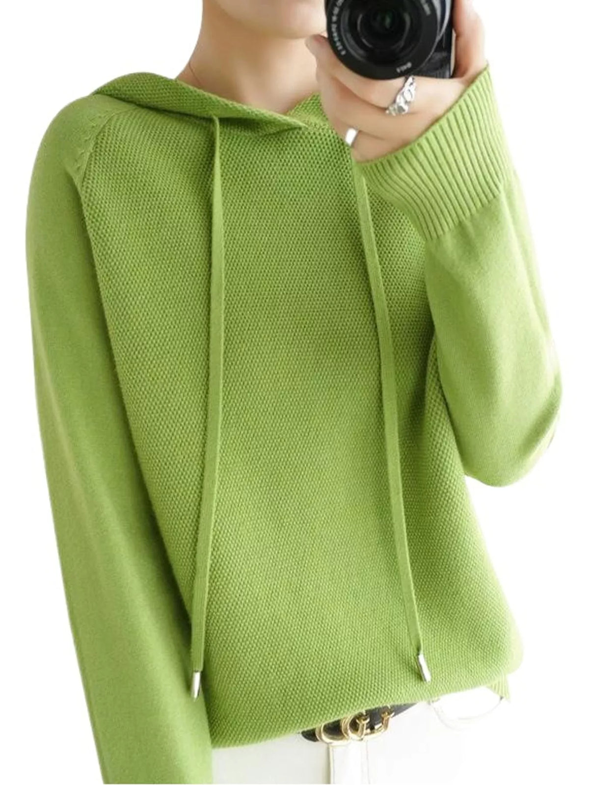 Light green hooded knit sweater shown in a front mirror photo with white trousers.