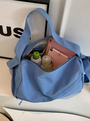 Blue duffel bag unzipped to show a tablet, drink bottle and rolled clothing inside