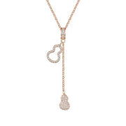 Rose-gold Y necklace laid flat, with gourd-shaped loop and dangling crystal drops