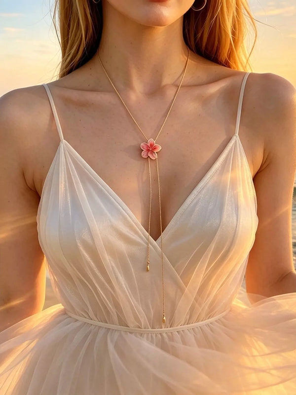 Long floral lariat necklace with pink flower pendant on a model