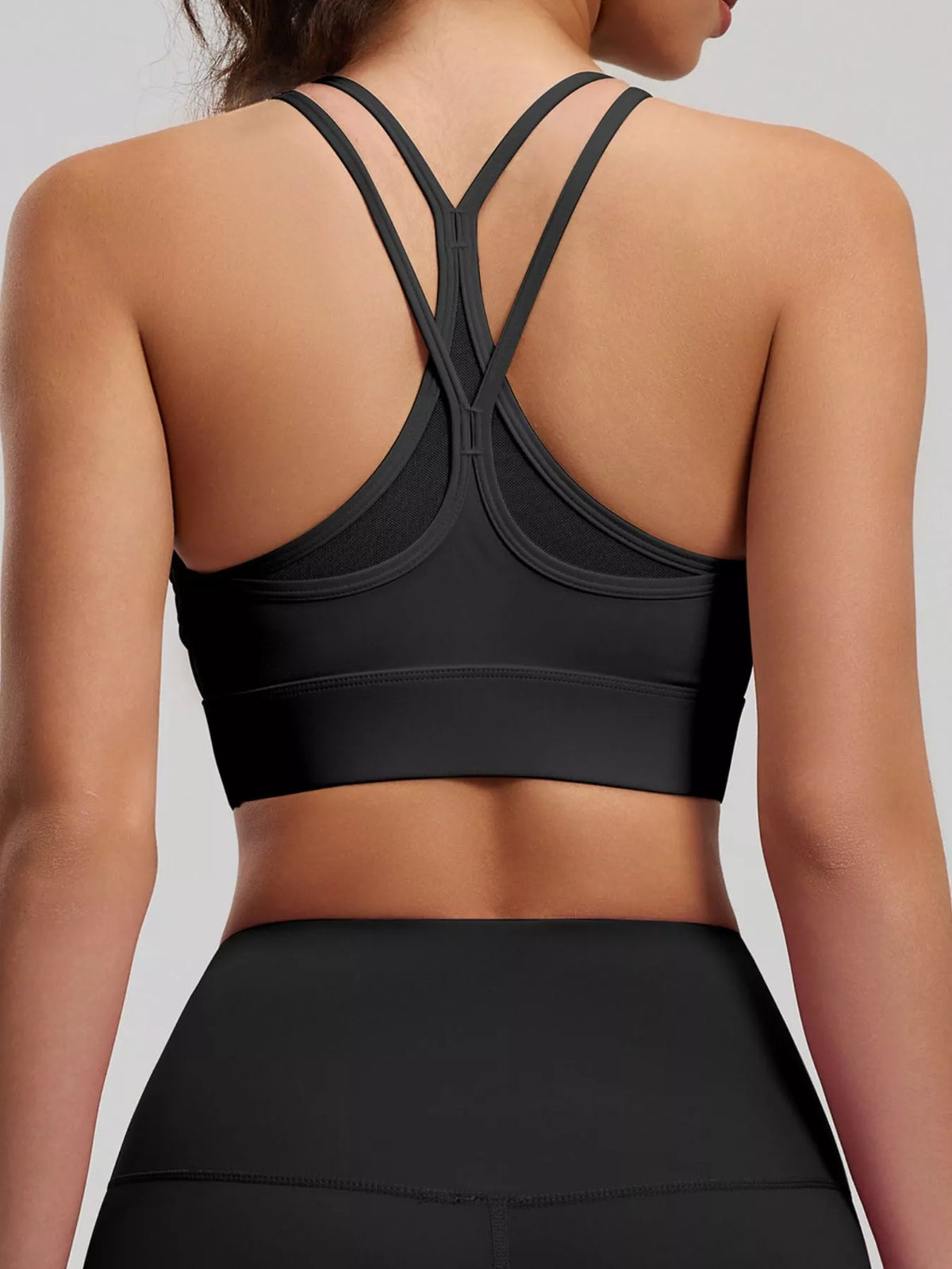 Rear view of black active bra with crossed double straps and wide underband