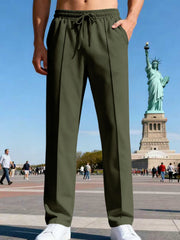 Side view of navy pants beside a rolling suitcase.