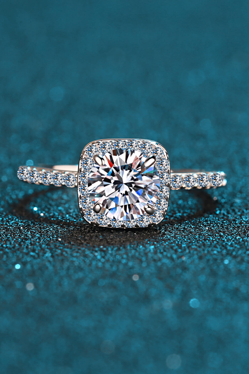 Front view of square halo ring with a pavé-set band on teal.