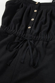 Black jumpsuit waist showing elastic gathering and drawstring tie