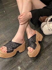 Black cross-strap platform sandals shown on crossed ankles from above