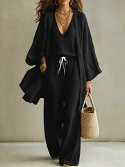 Woman wearing a black V-neck cardigan and matching pants from the three-piece set.