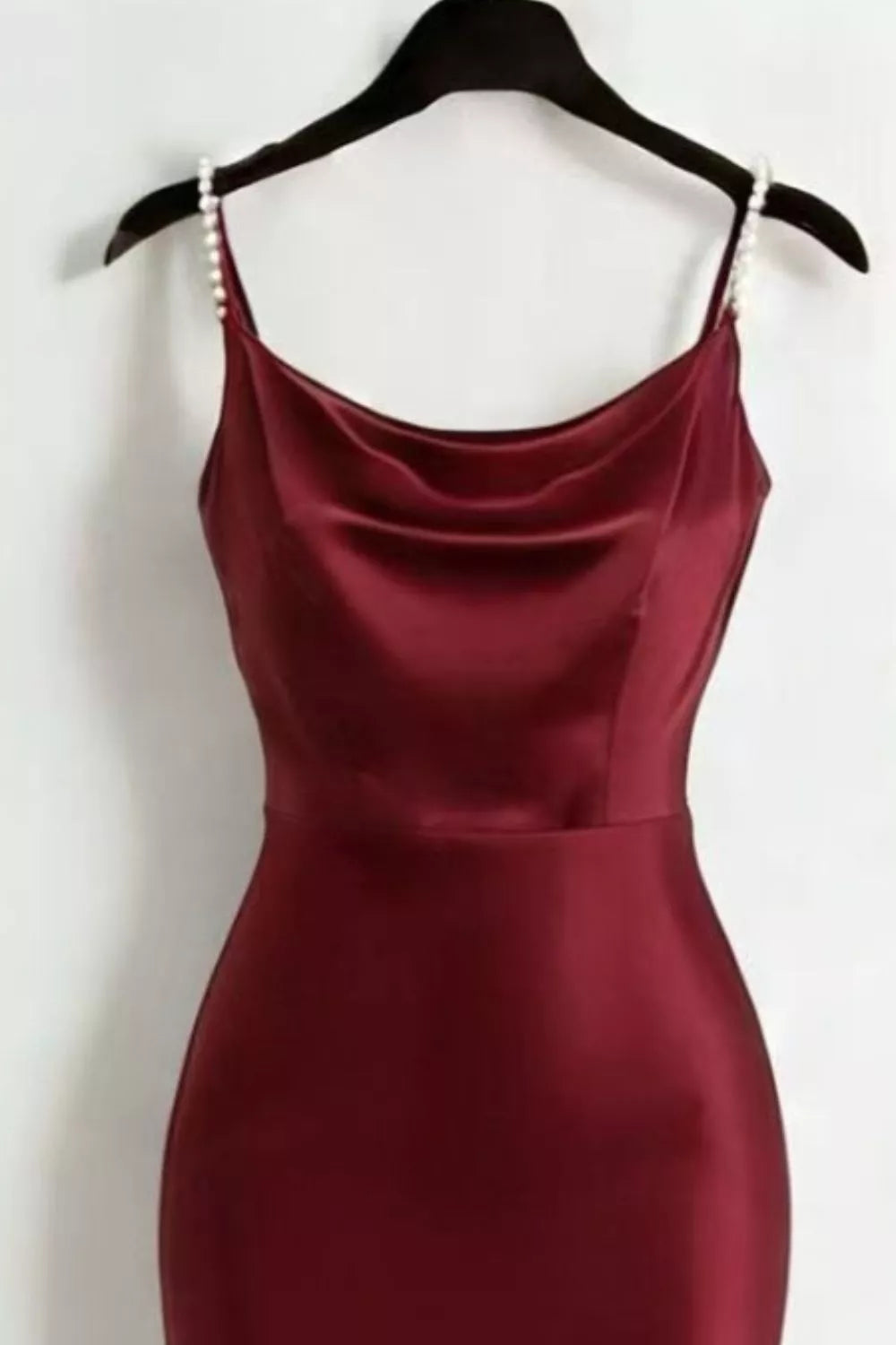 Close view of the burgundy satin dress's fitted bodice and cowl neckline.