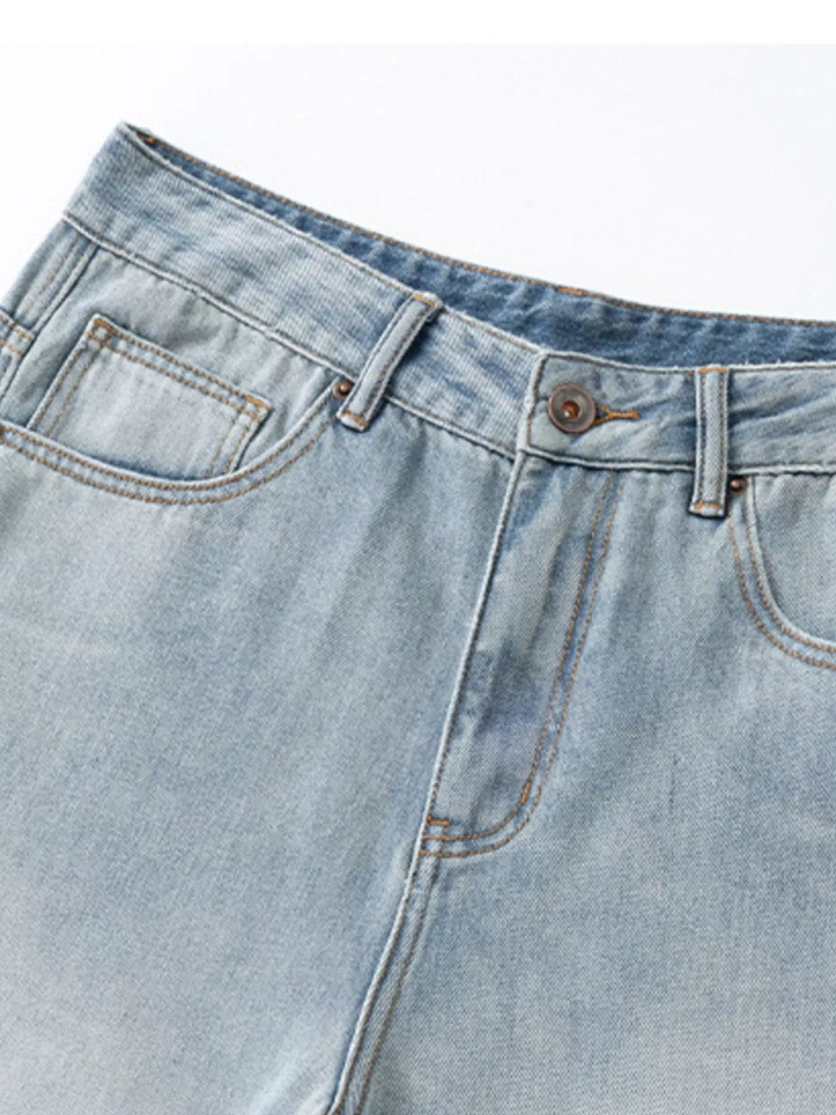 Close-up of light blue jeans waistband, button and front pockets