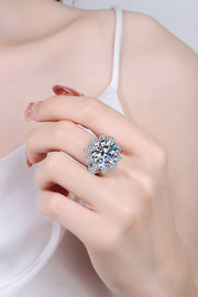 Flower-shaped moissanite ring worn on a finger, showing its large center stone