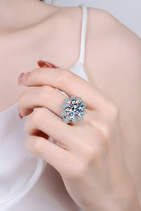 Flower-shaped moissanite ring worn on a finger, showing its large center stone