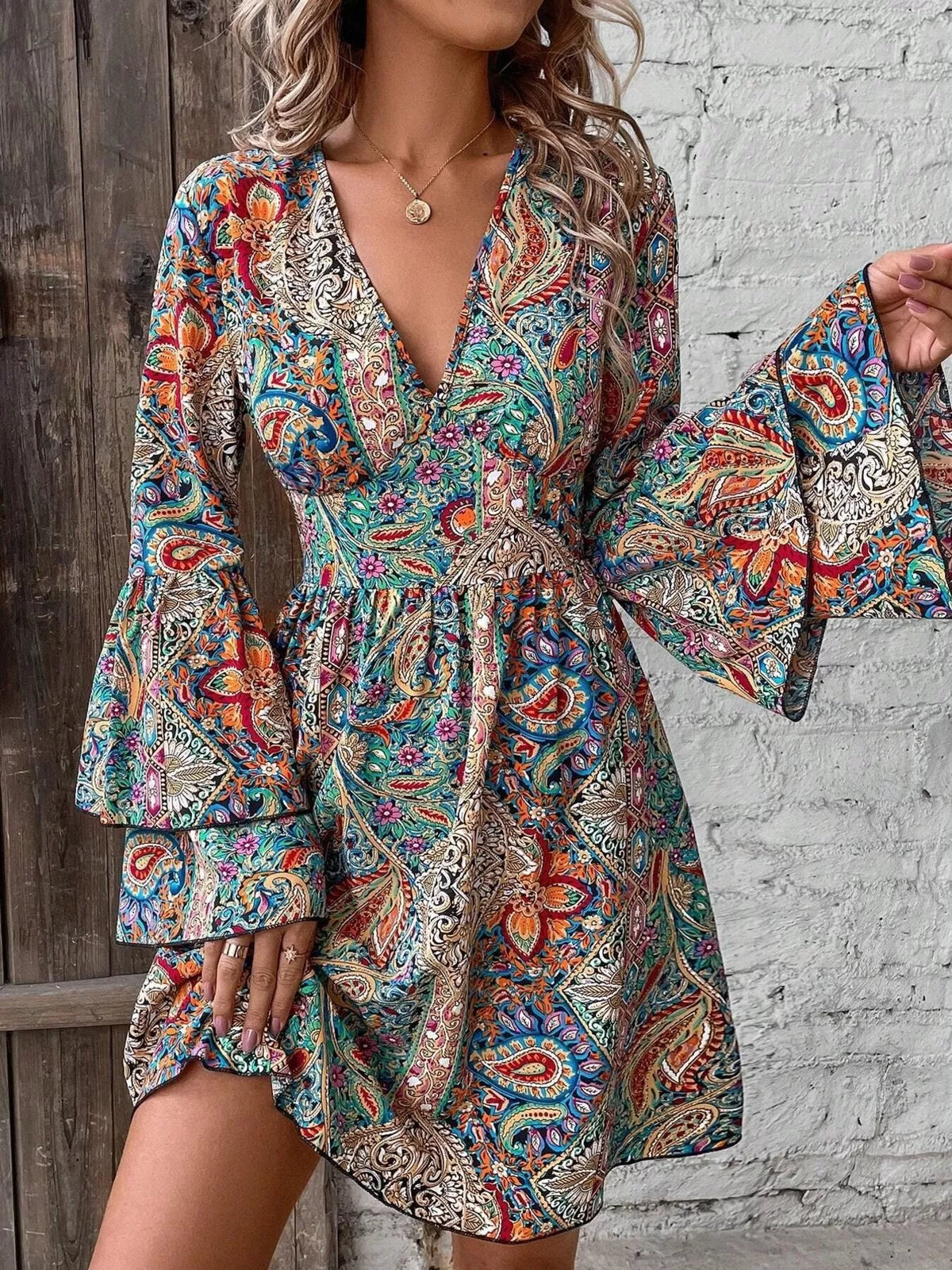 Close-up of paisley mini dress showing V-neck and layered bell sleeve