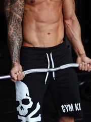 Model wearing black skull-print drawstring shorts
