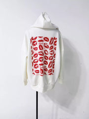 Close view of red lip-print panel on the back of a white hoodie