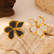 Gold-tone open flower rings with black and white petals displayed together