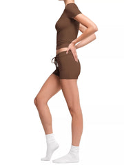 Woman modeling a brown ribbed mock-neck crop top and matching shorts, front view