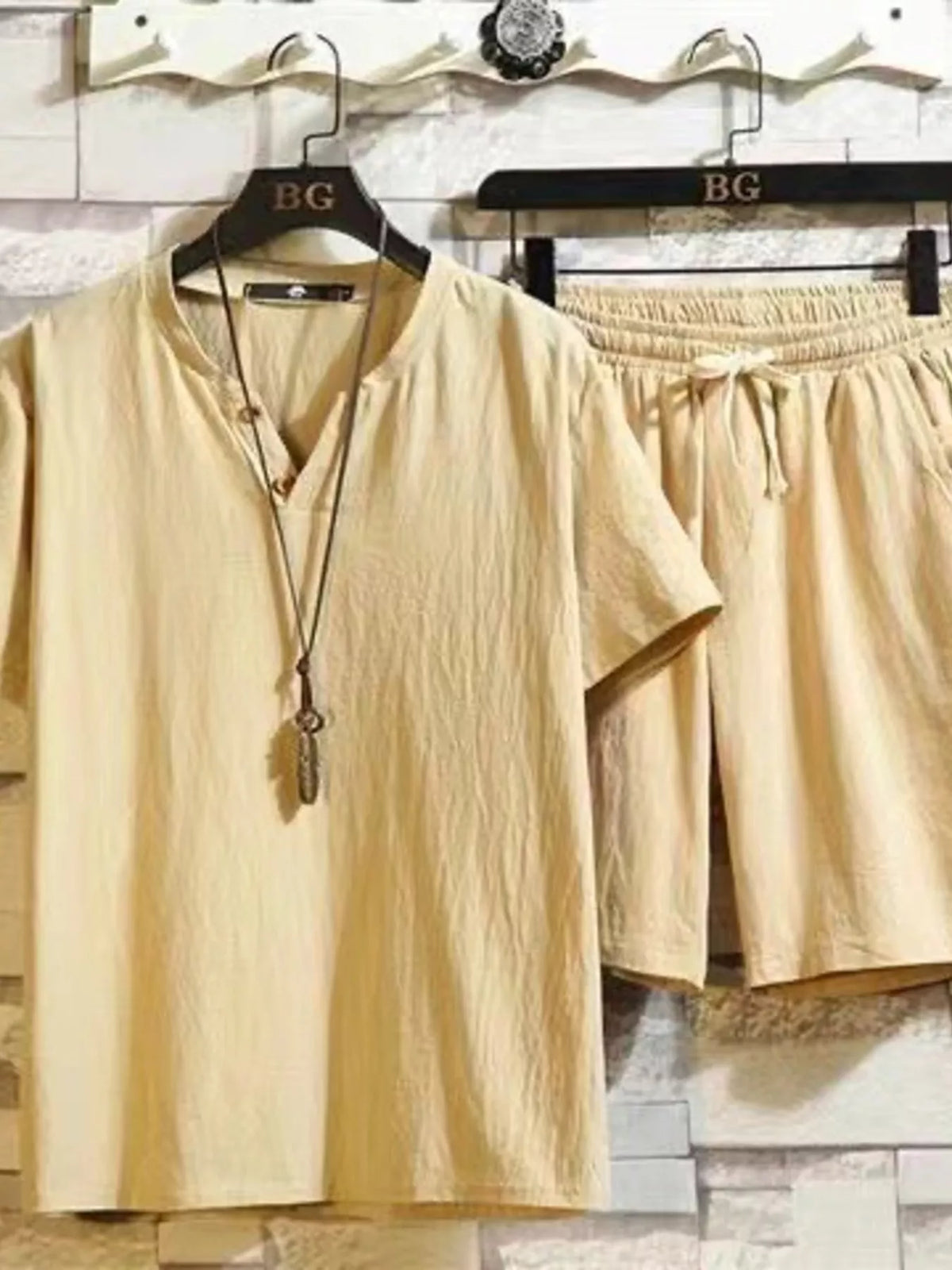 Pale yellow short-sleeve button-front shirt and matching drawstring shorts on hangers