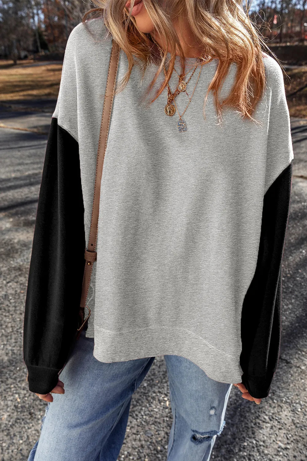 Model wearing gray sweatshirt with black sleeves
