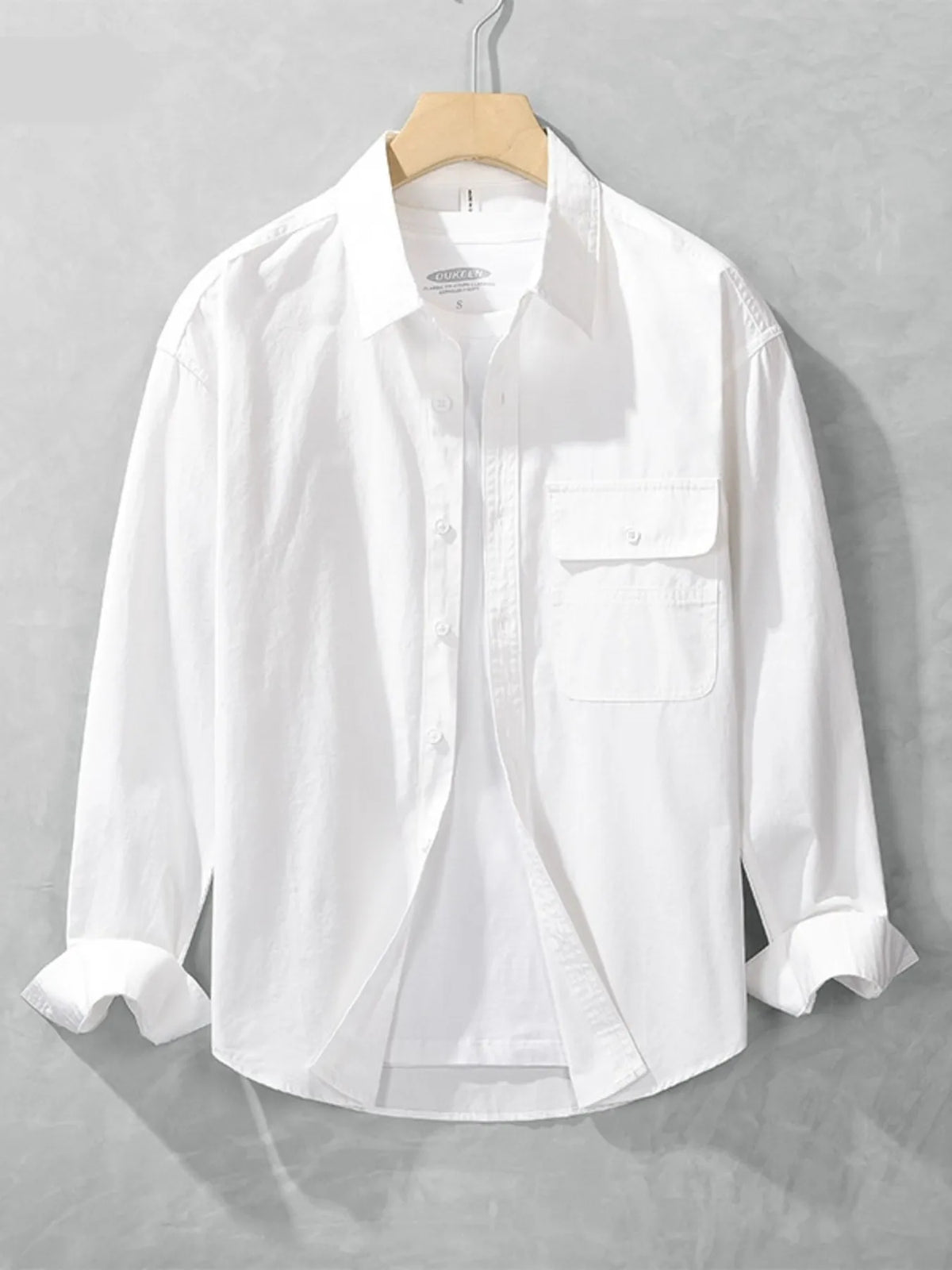 White long-sleeve men's button-up shirt shown from the front with button placket and chest pocket