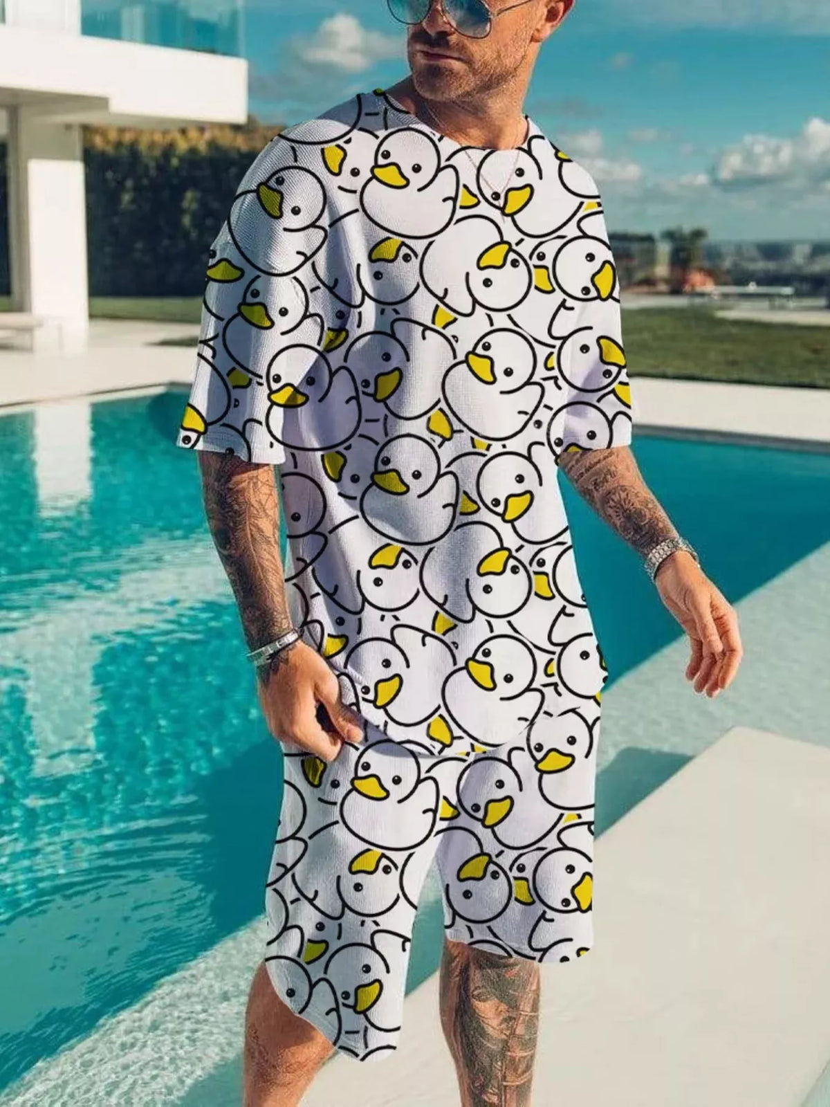 White short-sleeve tee and shorts set with repeating outlined cartoon faces and yellow details.