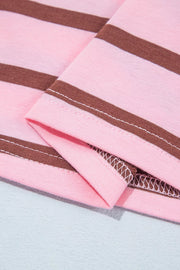Close view of pink shirt fabric with brown stripe and stitched edge.