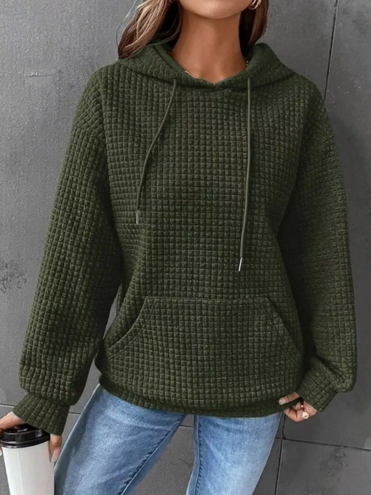 Olive green textured hoodie worn with jeans