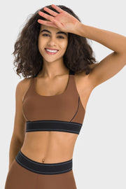 Model wearing a brown contrast sports bra with black hem band