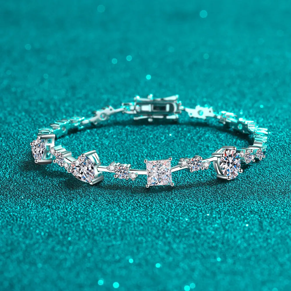 Silver-tone moissanite bracelet with geometric stones displayed on teal fabric