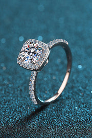 Angled view of square halo moissanite ring against a teal textured backdrop.