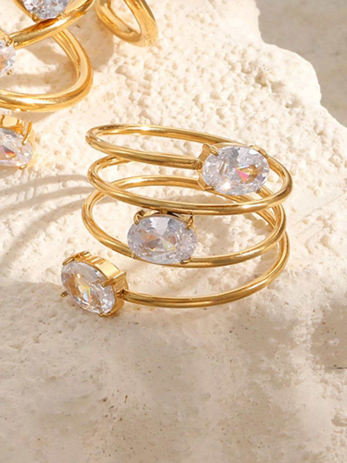 Close-up of three oval clear stones on a stacked open ring