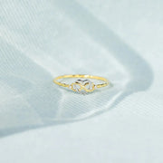 Infinity-heart ring displayed on pale blue fabric
