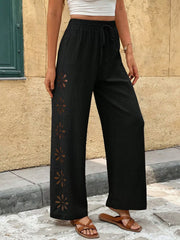 Close view of black pants with flower-shaped embroidery