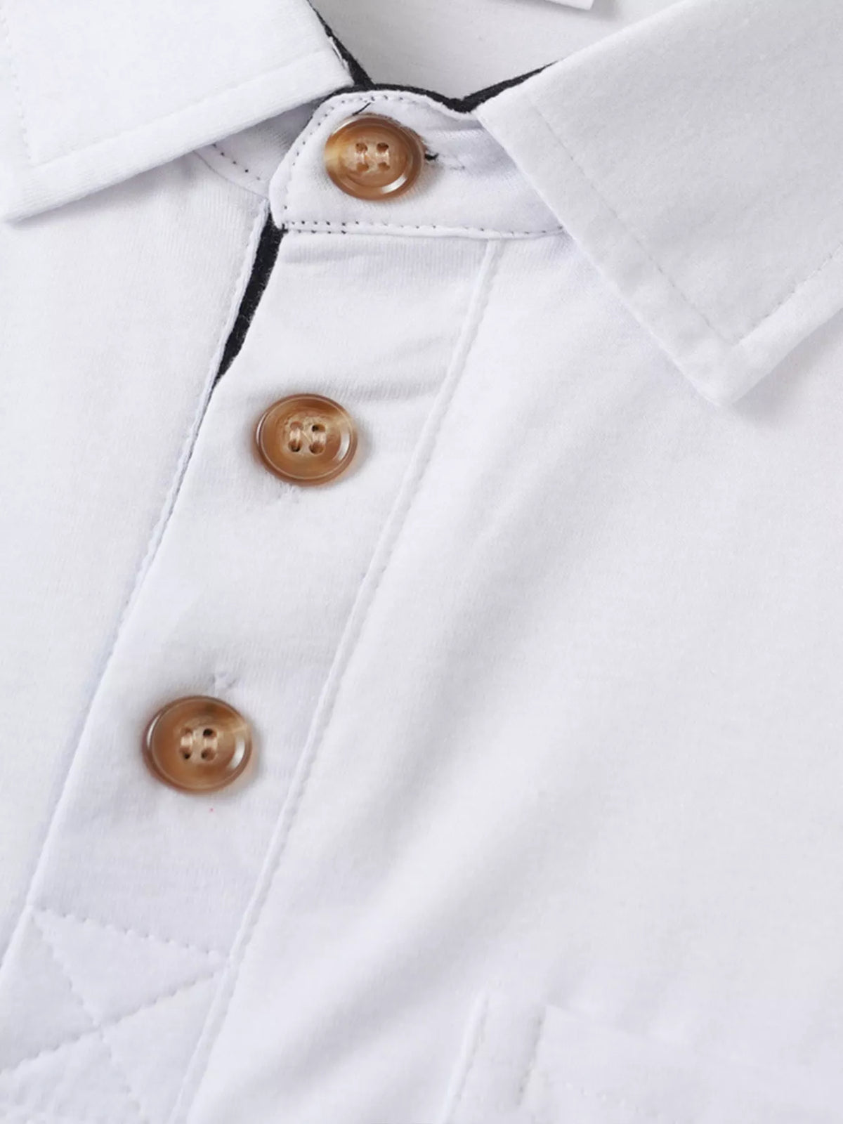 Close-up of contrast buttons on white polo shirt