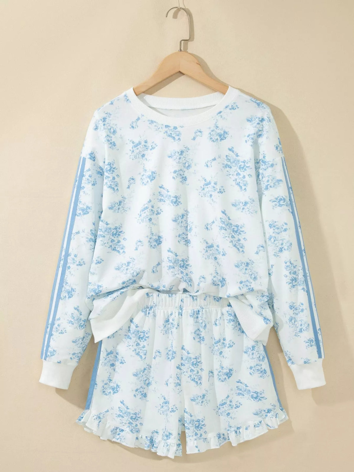 White floral sweatshirt and shorts set displayed on a hanger, front