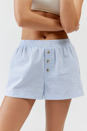 Pale blue striped elastic-waist shorts: front view with button placket