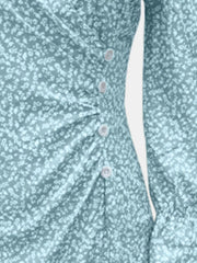 Close-up of mint blue dress print, waist ruching and button detail