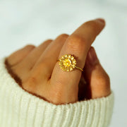 Gold-tone sunflower ring worn on a hand
