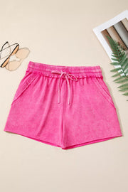 Pink drawstring shorts laid flat, front view