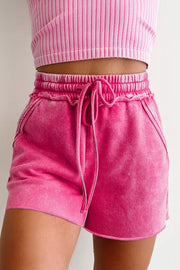 Close view of pink shorts showing elastic waist and tied drawstring