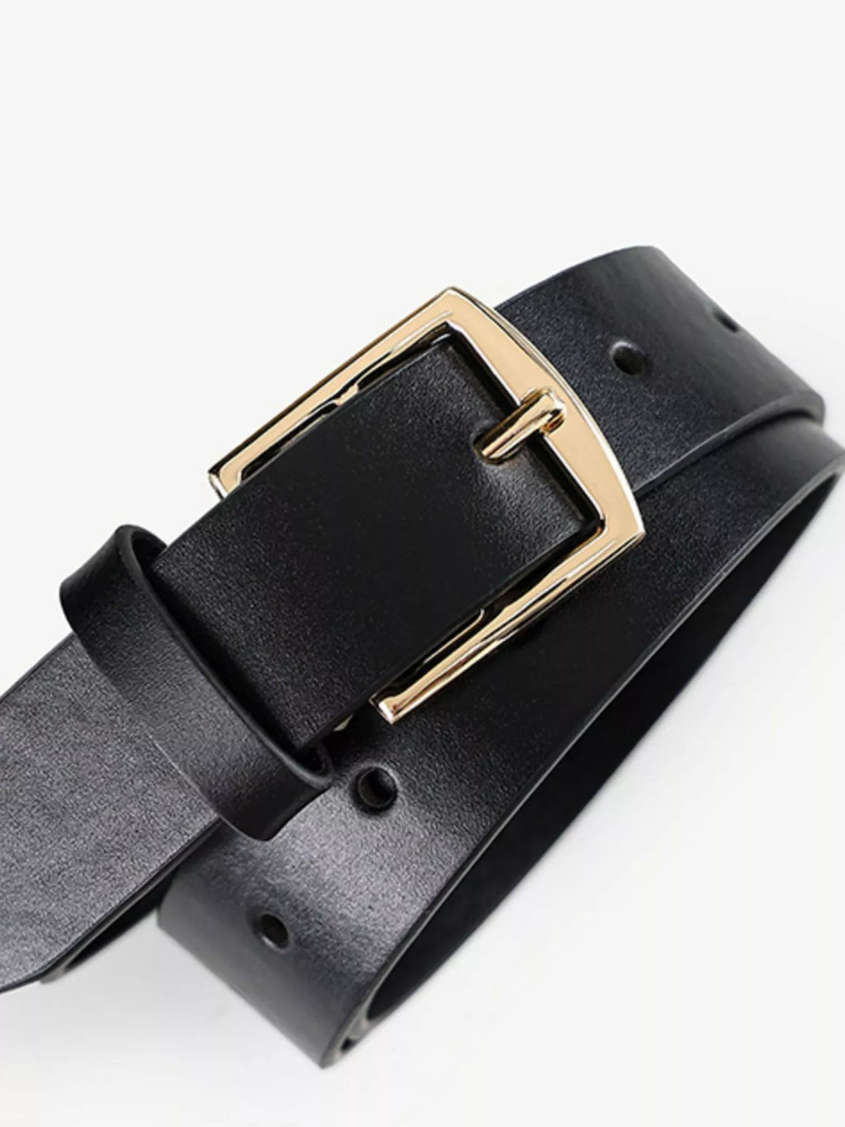 Close-up of black belt threaded through a gold-coloured rectangular buckle