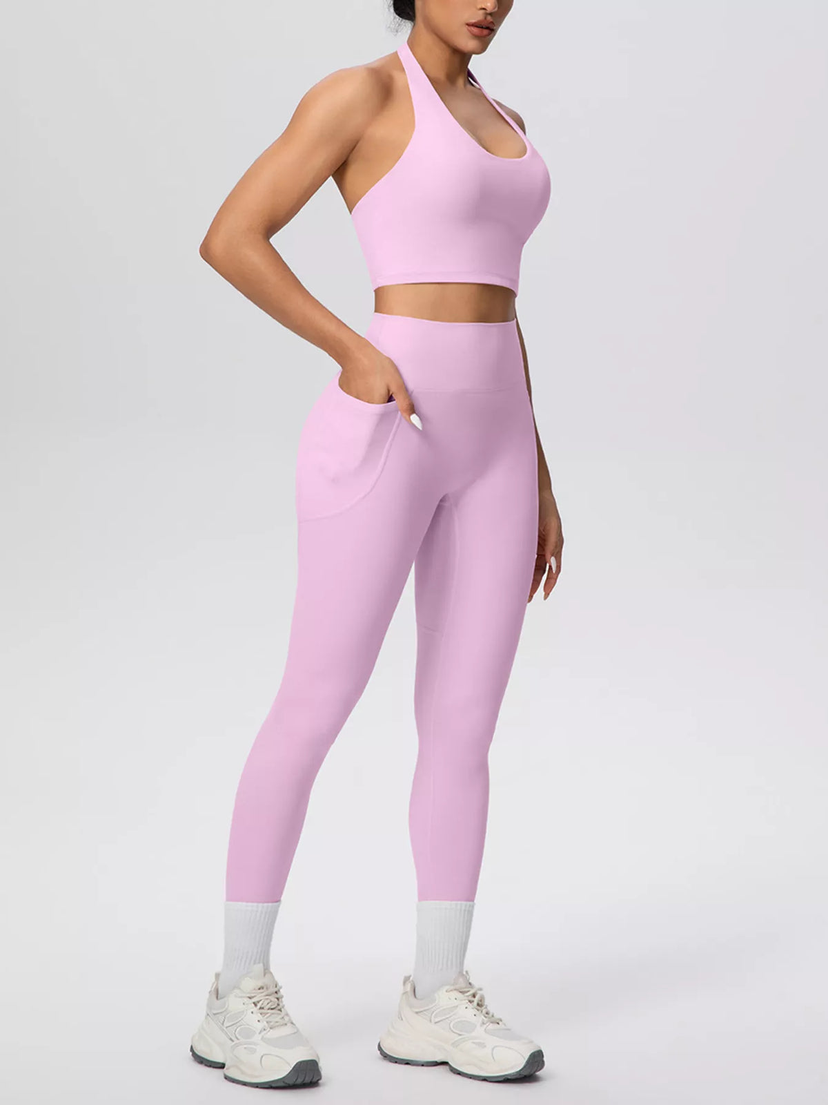 Angled view of pink halter set with phone pocket on leggings