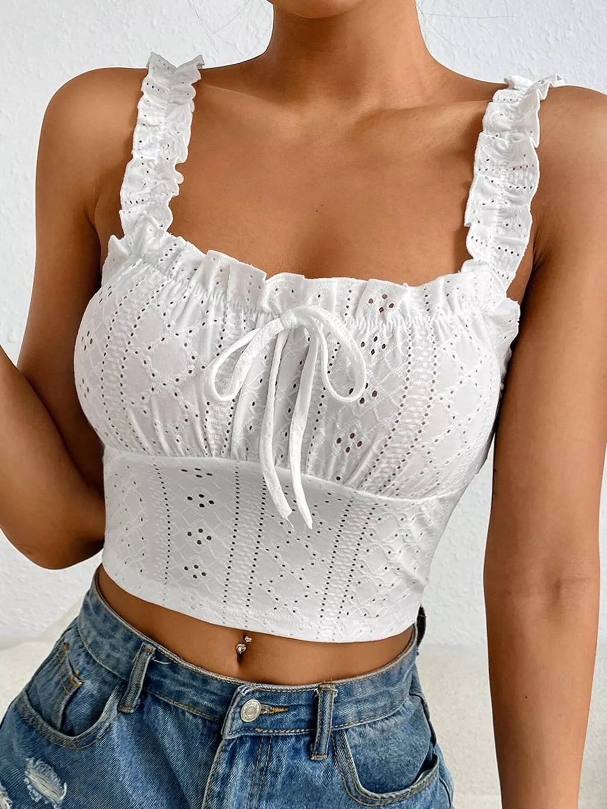 Close-up of white eyelet bodice and ruffled straps with front tie