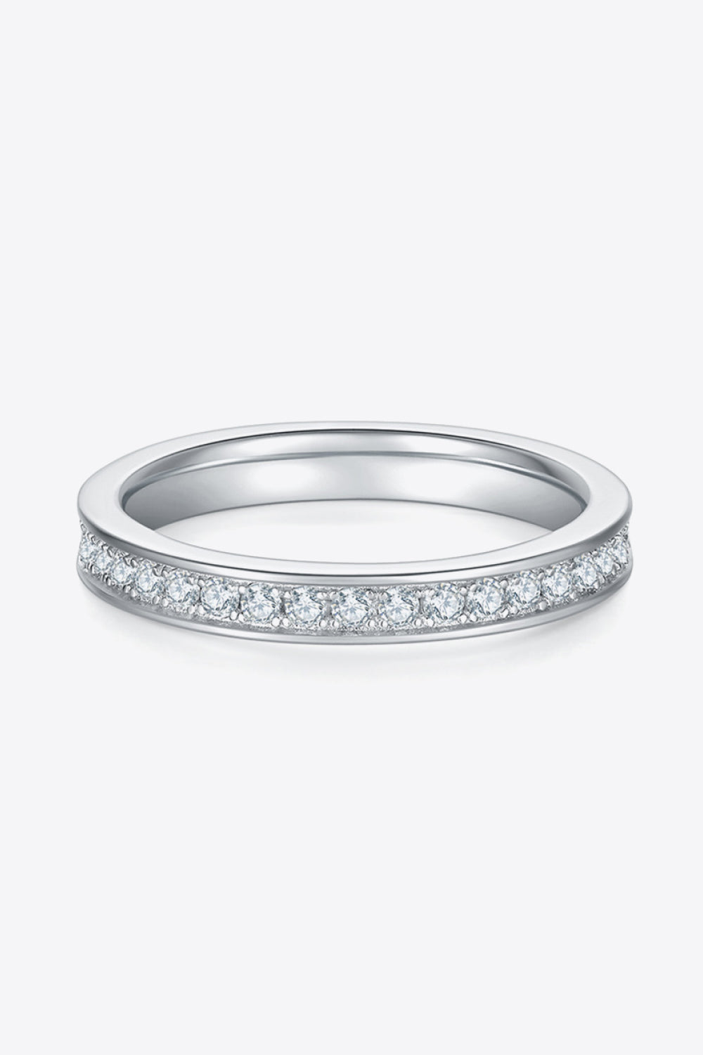 Low side view of a narrow moissanite band with a row of stones on white.