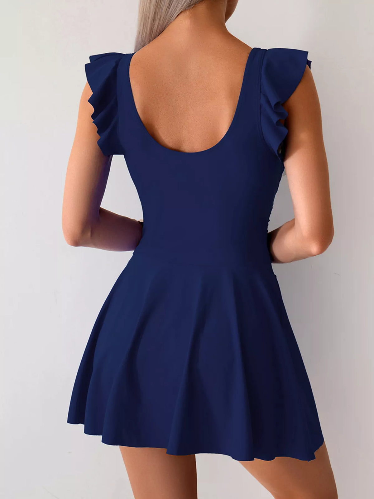 Navy swim dress shown from the back with a low back neckline