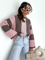 Model standing in pink and brown oversized sweater with wide sleeves