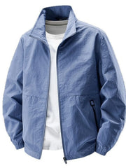 Blue stand-collar zip jacket displayed open over a white T-shirt with zippered side pockets